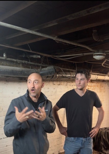Anthony Setaro and a collaborator standing in a brick-walled cellar