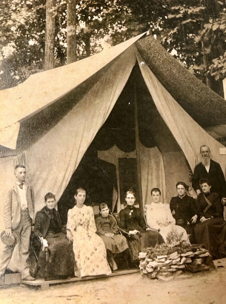 Sepia historical photograph of a Victorian-era family posed in front of their canvas tent in Ocean Grove